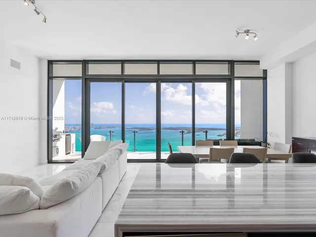 a living room with furniture and floor to ceiling windows