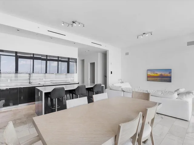 a large white kitchen with a table and chairs in it