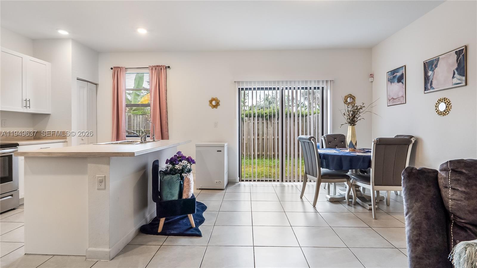 13410 Southwest 287th Terrace Homestead, FL 33033 - Photo 15 of 32 a kitchen with a dining table chairs and large windows