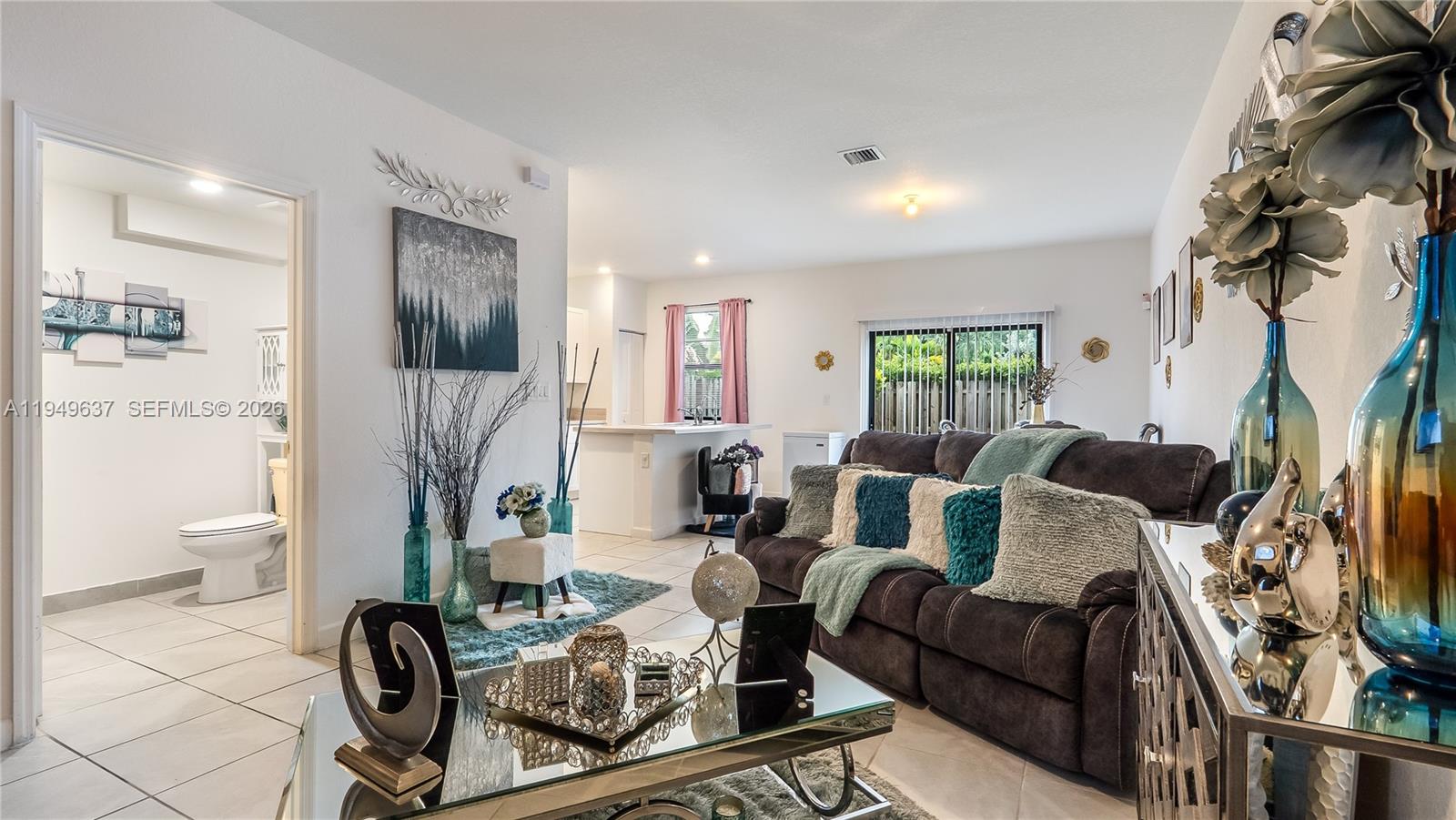 13410 Southwest 287th Terrace Homestead, FL 33033 - Photo 10 of 32 a living room with furniture a flat screen tv and a fireplace