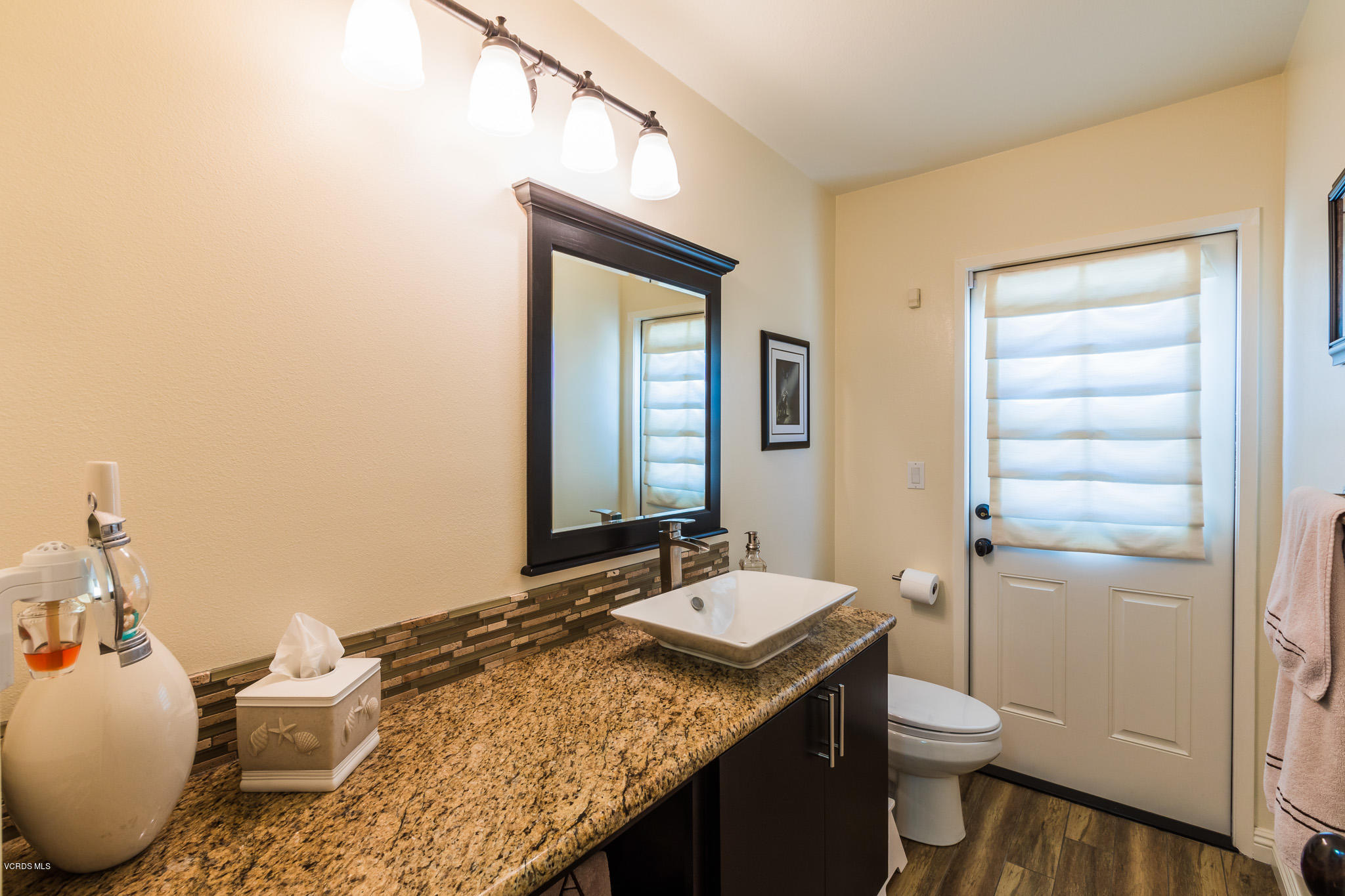 660 Appleton Road Simi Valley, CA 93065 - Photo 22 of 47 a bathroom with a granite countertop sink toilet and mirror