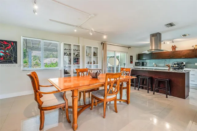 a dining room with furniture and a floor to ceiling window