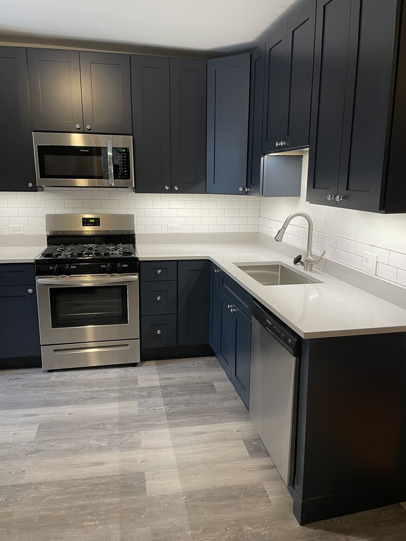 1834 South Racine Avenue Chicago, IL 60608 - Photo 2 of 36 a kitchen with stainless steel appliances granite countertop wooden cabinets a stove top oven a sink and dishwasher