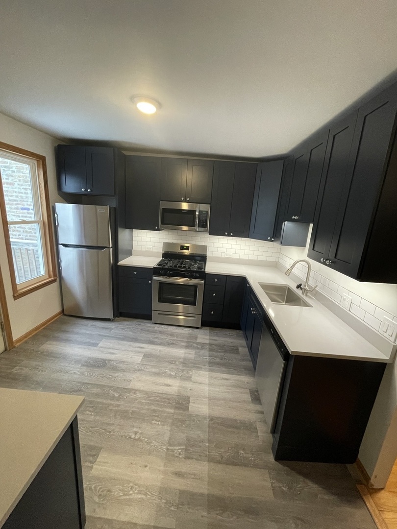 1834 South Racine Avenue Chicago, IL 60608 - Photo 21 of 36 a kitchen with a sink cabinets and stainless steel appliances