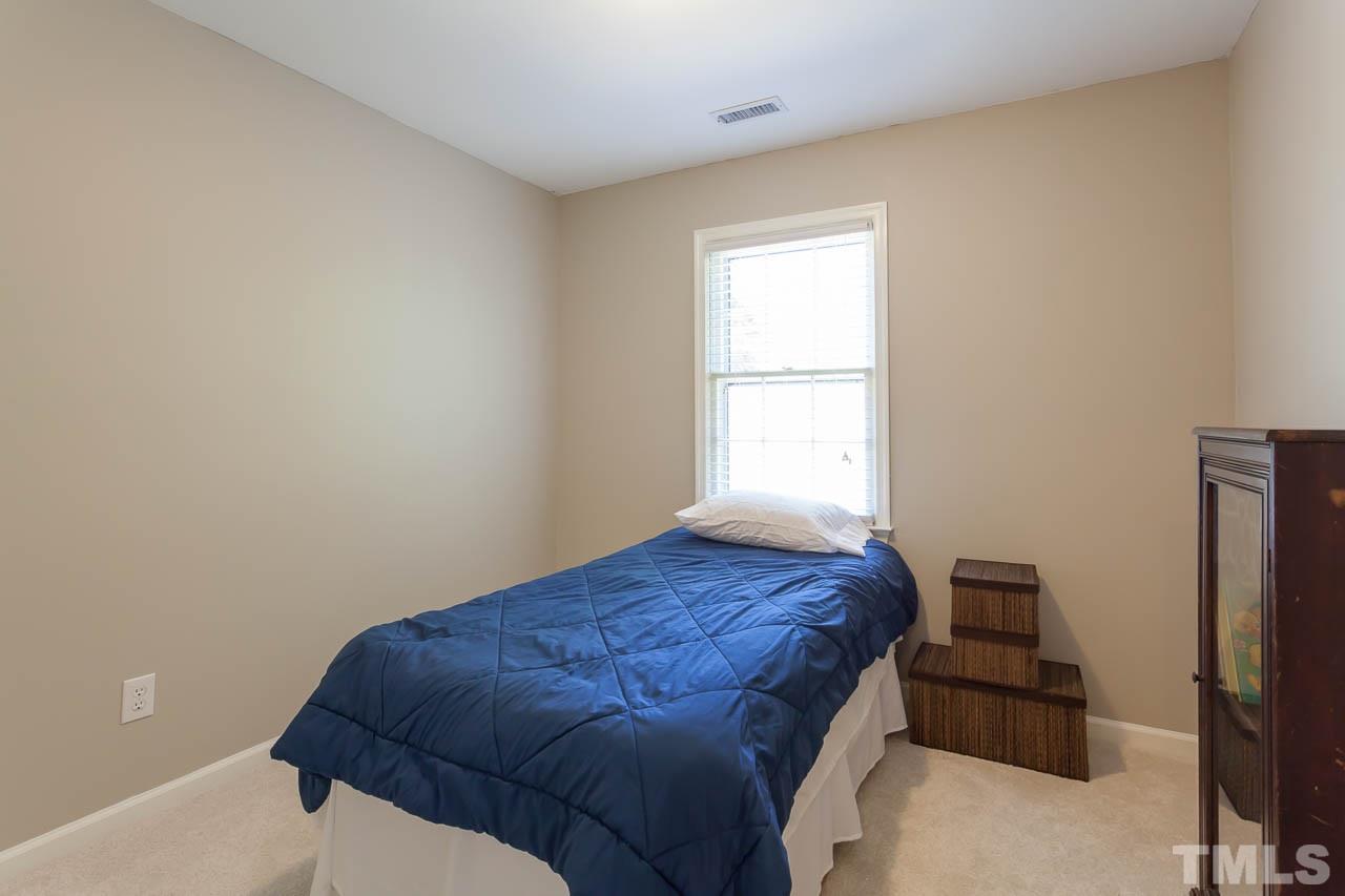 5509 Banwell Place Raleigh, NC 27613 - Photo 14 of 17 a bedroom with a bed and a window
