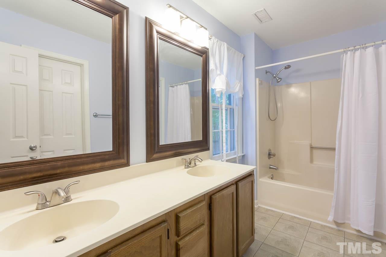 5509 Banwell Place Raleigh, NC 27613 - Photo 15 of 17 a bathroom with a shower sink vanity and mirror