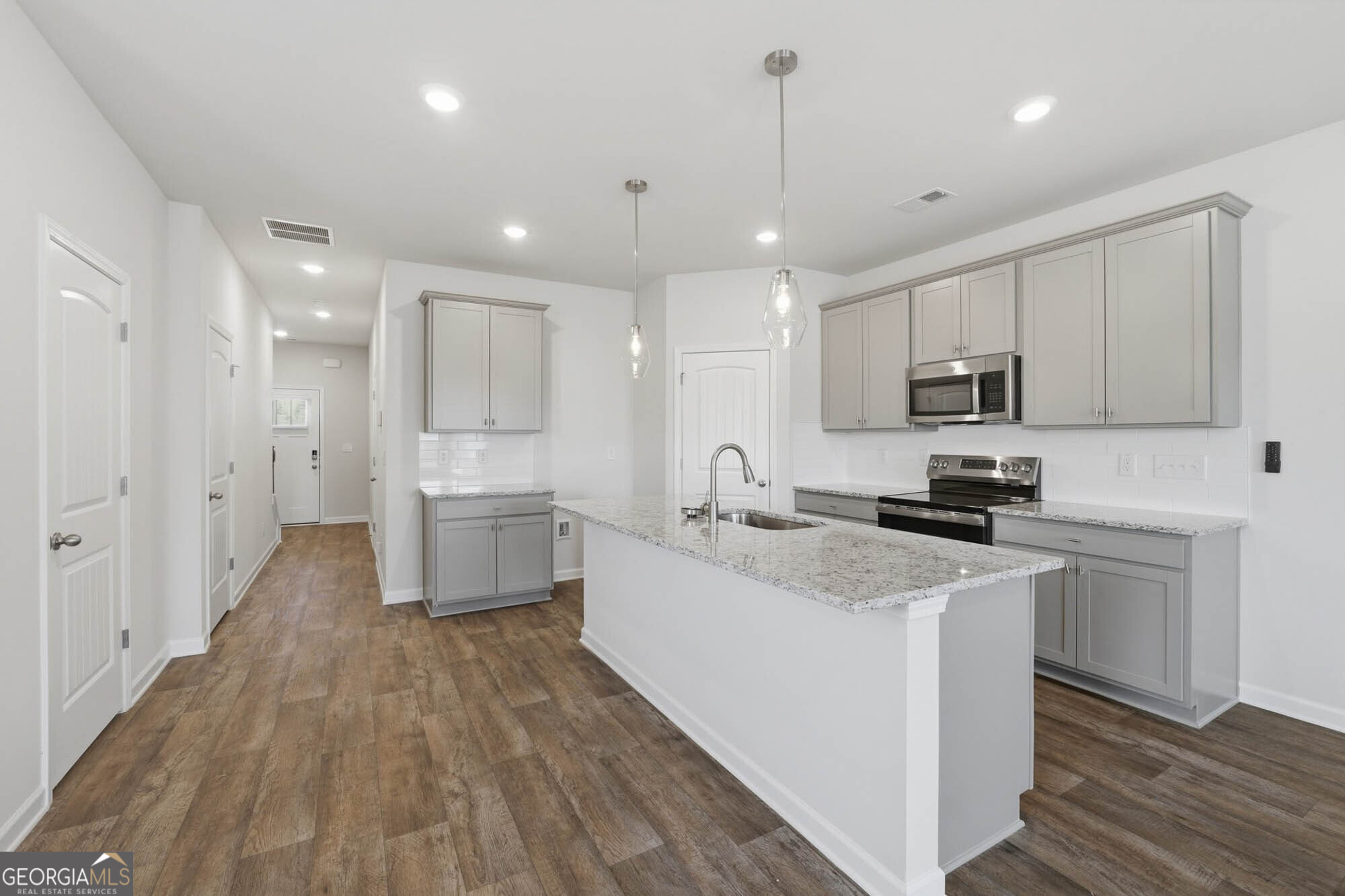 5284 Magnolia Grove Way Gainesville, GA 30504 - Photo 22 of 31 a kitchen with white cabinets and stainless steel appliances
