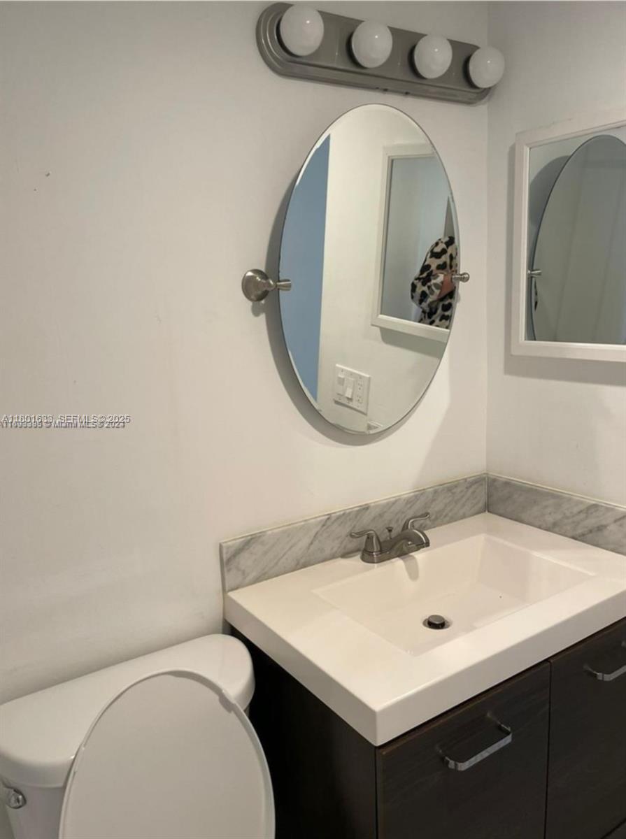 4164 Inverrary Drive, Unit 301 Lauderhill, FL 33319 - Photo 13 of 19 a bathroom with a toilet sink and mirror