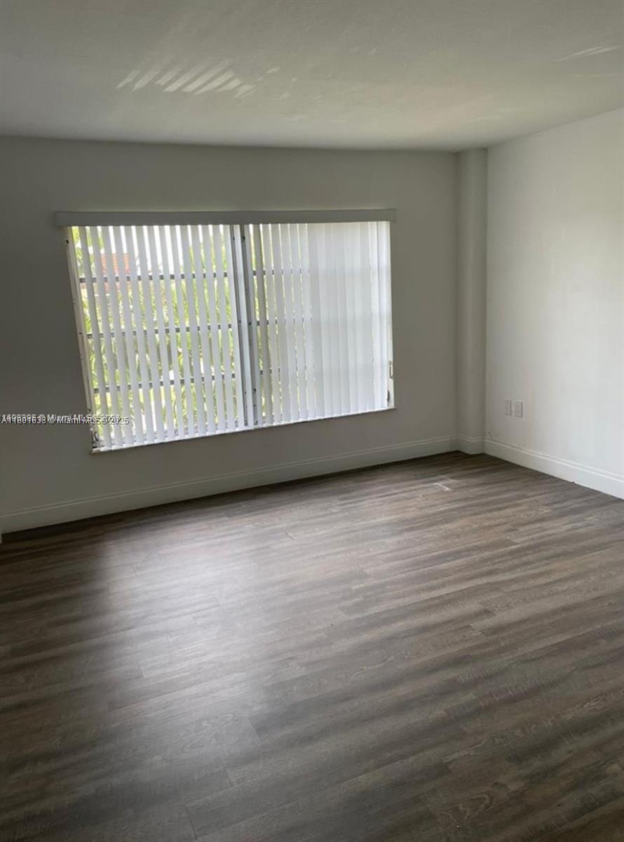 4164 Inverrary Drive, Unit 301 Lauderhill, FL 33319 - Photo 6 of 19 a view of an empty room with wooden floor and a window