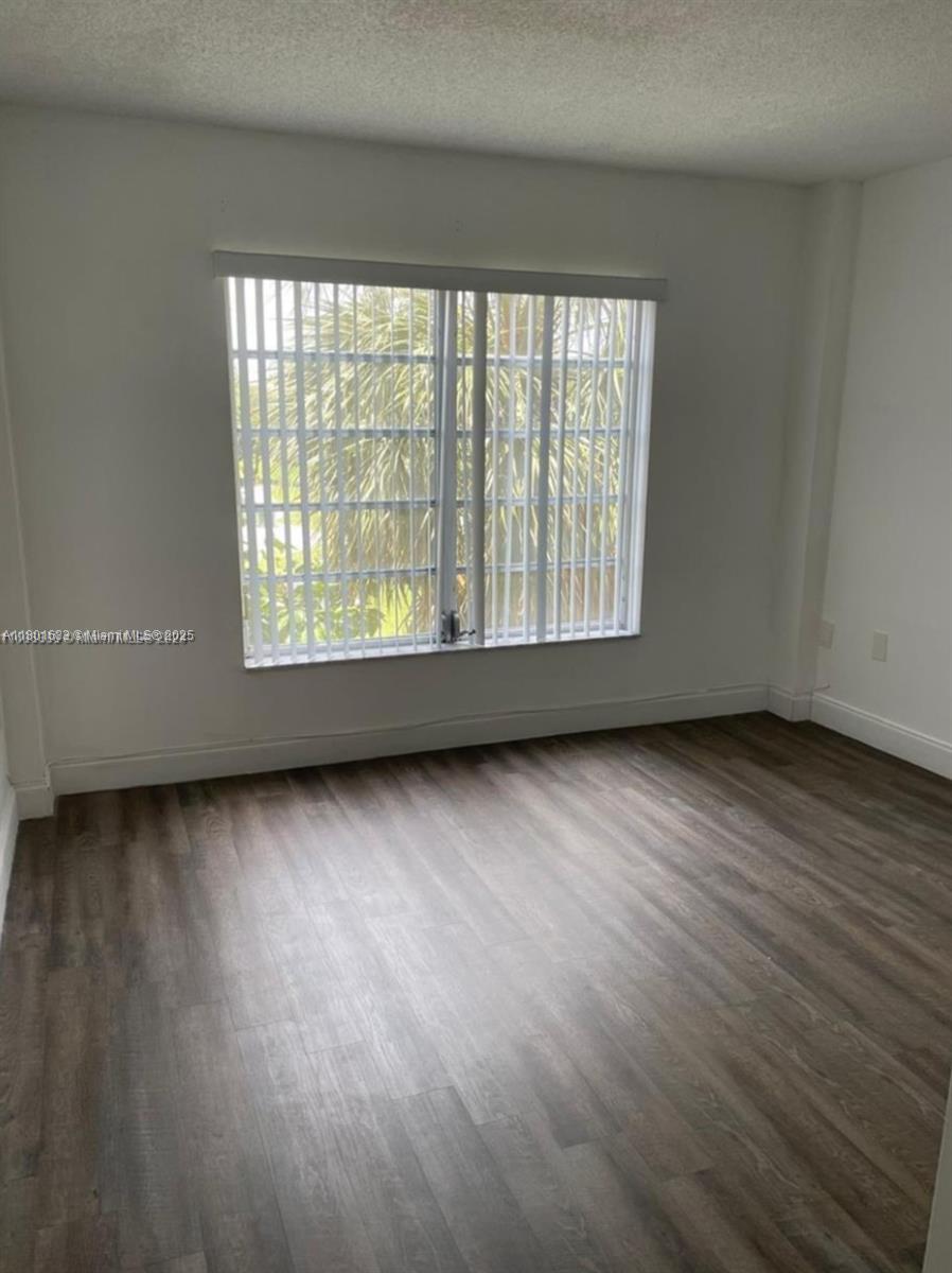 4164 Inverrary Drive, Unit 301 Lauderhill, FL 33319 - Photo 9 of 19 an empty room with wooden floor and windows