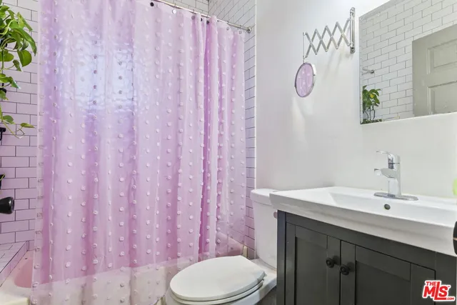 a bathroom with a sink a toilet and shower curtain