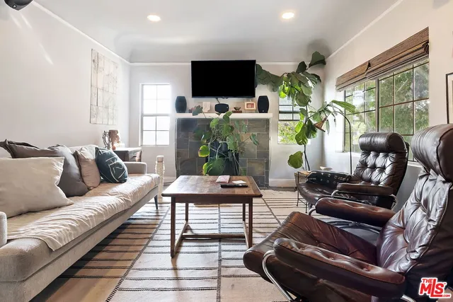 a living room with furniture flat screen tv and a large window