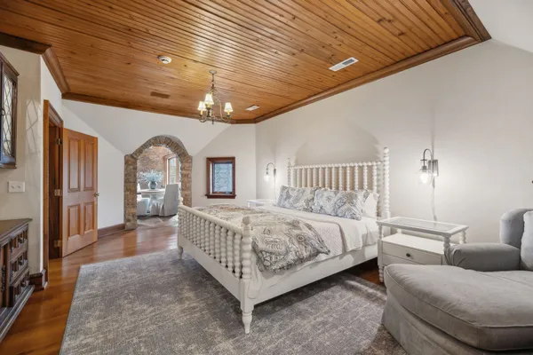 a bedroom with a bed couch and a flat screen tv