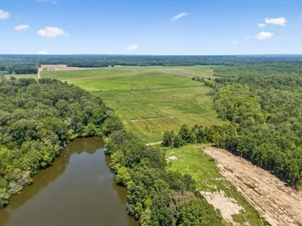 a dining room with wooden floor a chandelier a wooden table and chairs