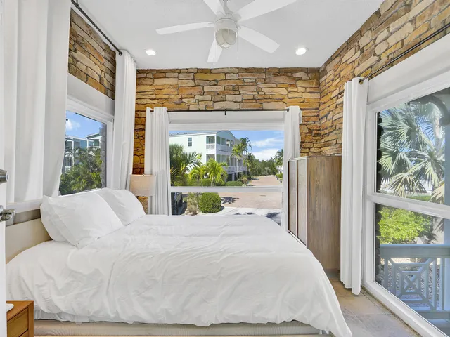 a large white bed sitting in front of a window