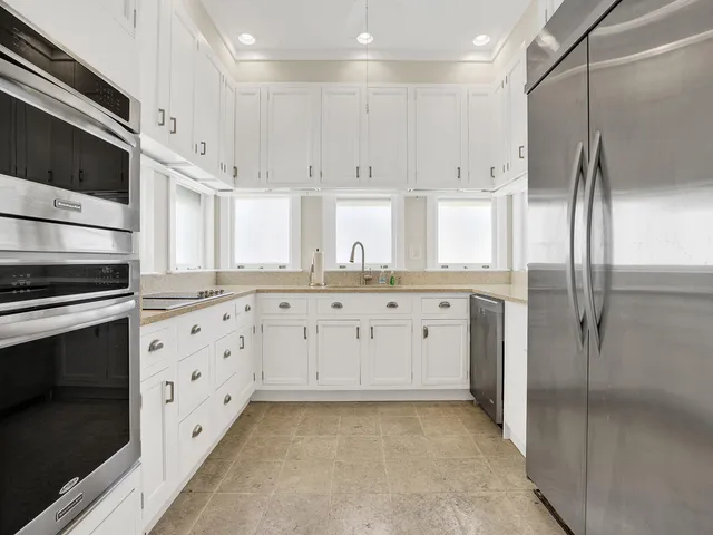 a kitchen with stainless steel appliances a refrigerator sink and cabinets
