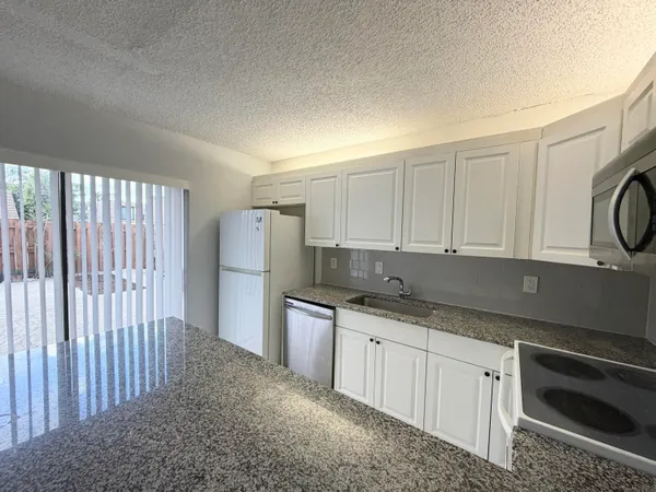 a kitchen with a sink a stove and cabinets