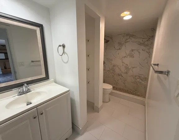 a bathroom with a sink a toilet and shower