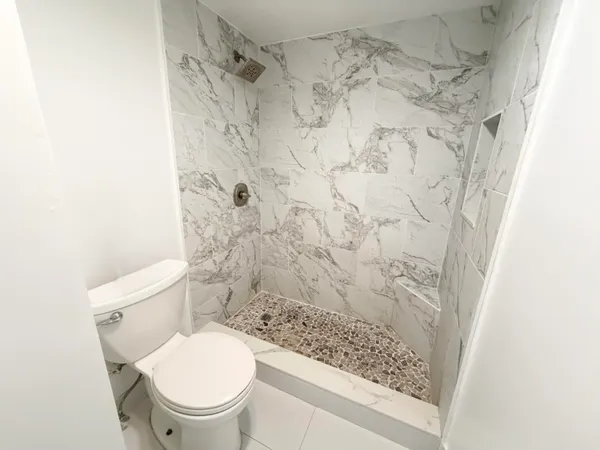 a white toilet sitting next to a shower curtain