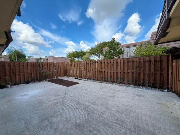 a view of backyard with wooden fence