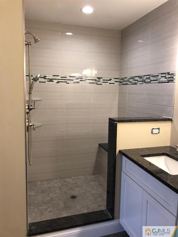 42 Crescent Road Edison, NJ 08817 - Photo 14 of 20 a bathroom with a shower a mirror and a sink