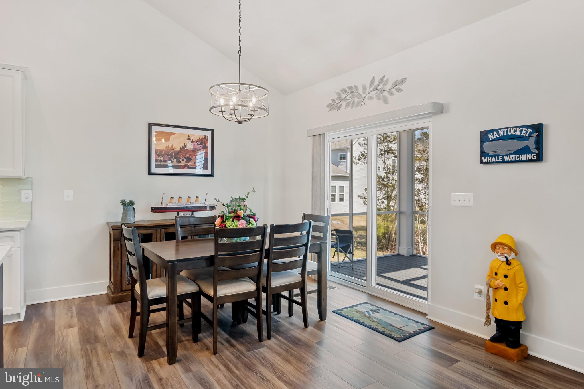 19437 Longfellow Way Georgetown, DE 19947 - Photo 14 of 33 a view of a dining room with furniture wooden floor and chandelier
