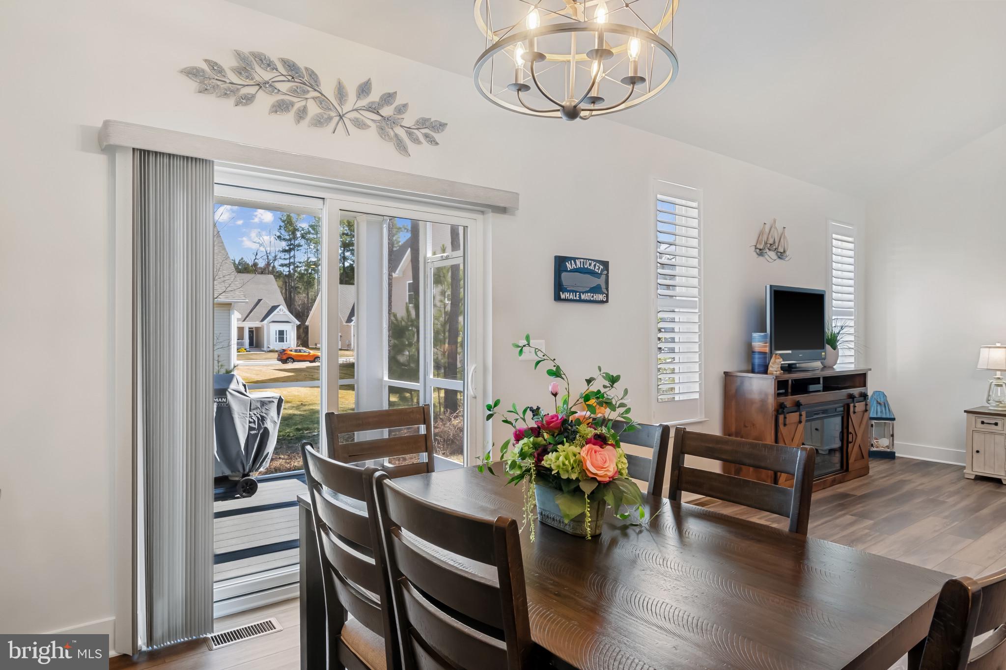 19437 Longfellow Way Georgetown, DE 19947 - Photo 18 of 33 a view of a dining room with furniture wooden floor and a chandelier