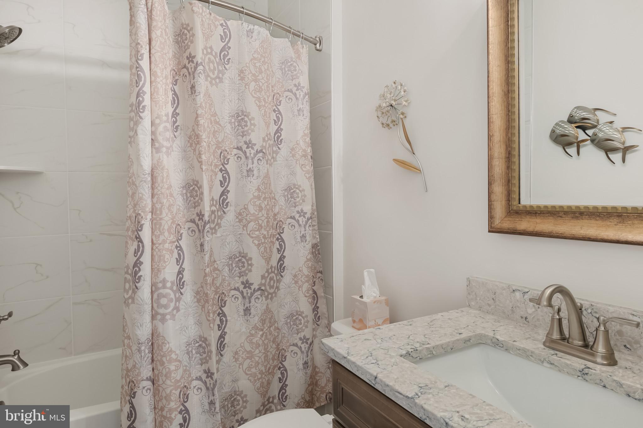 19437 Longfellow Way Georgetown, DE 19947 - Photo 21 of 33 a bathroom with a granite countertop sink and a mirror