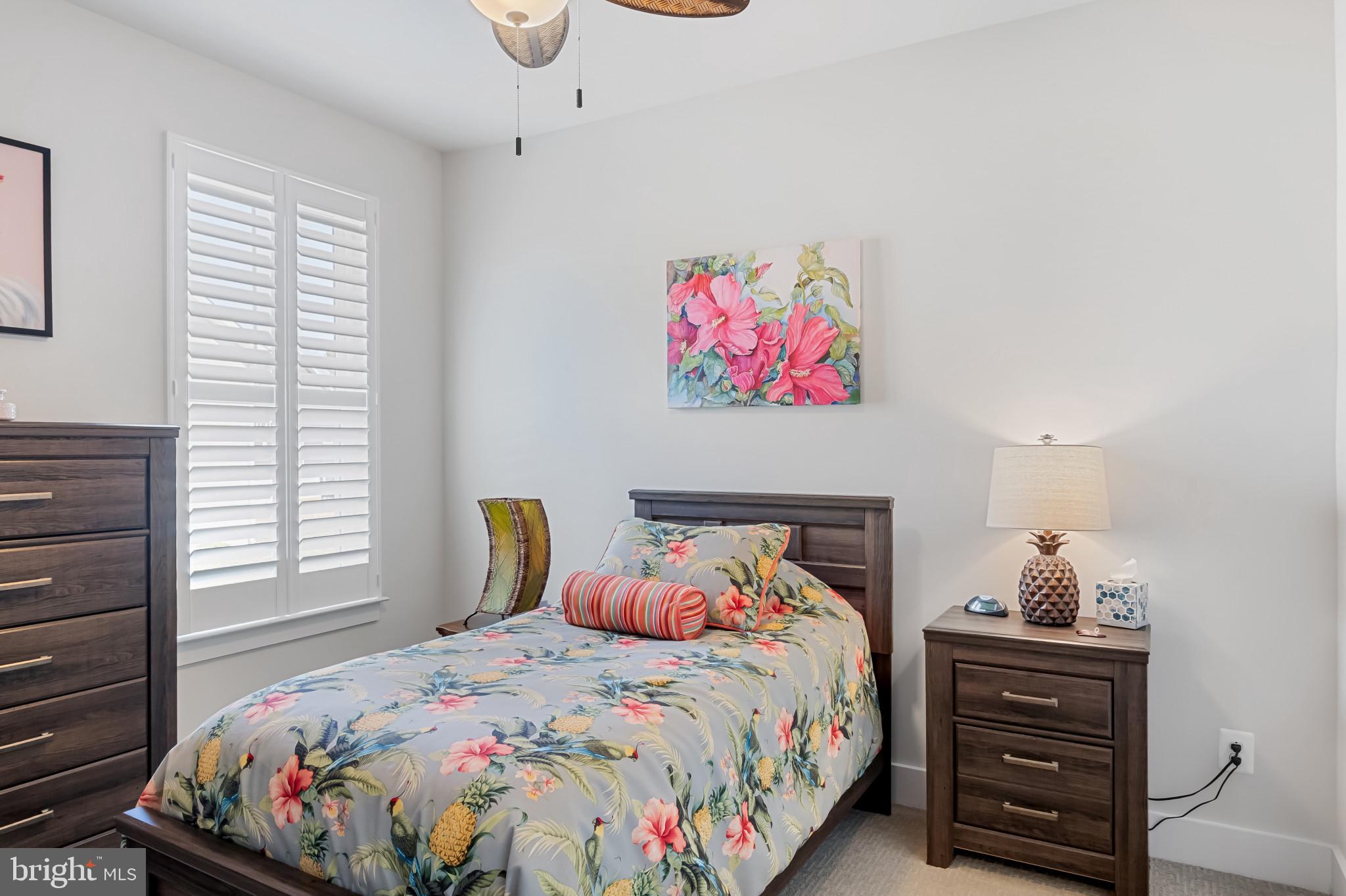 19437 Longfellow Way Georgetown, DE 19947 - Photo 22 of 33 a bedroom with a bed a dresser and paintings on the wall