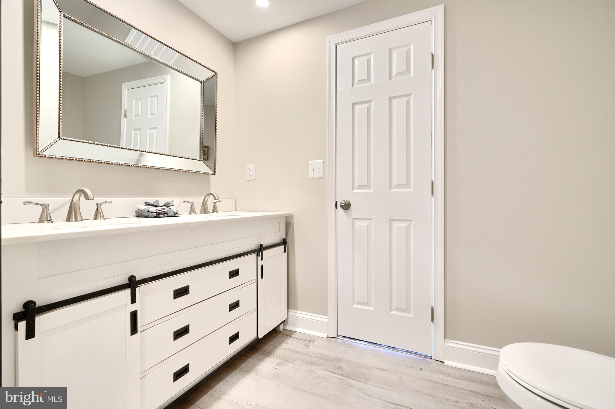 235 Pinewood Road Dundalk, MD 21222 - Photo 37 of 59 a bathroom with a sink a toilet and a mirror