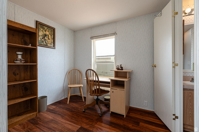 740 Riddle Drive Fredonia, AZ 86022 - Photo 9 of 20 Room featuring wood-finish flooring, a single window, and light-colored textured wall panels