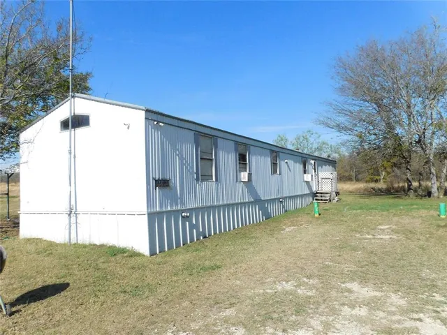 a view of a house with a backyard and a tree