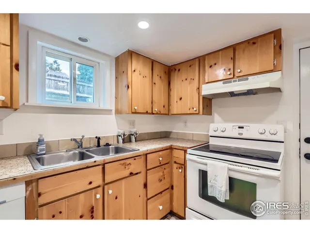 a kitchen with a sink a refrigerator and cabinets
