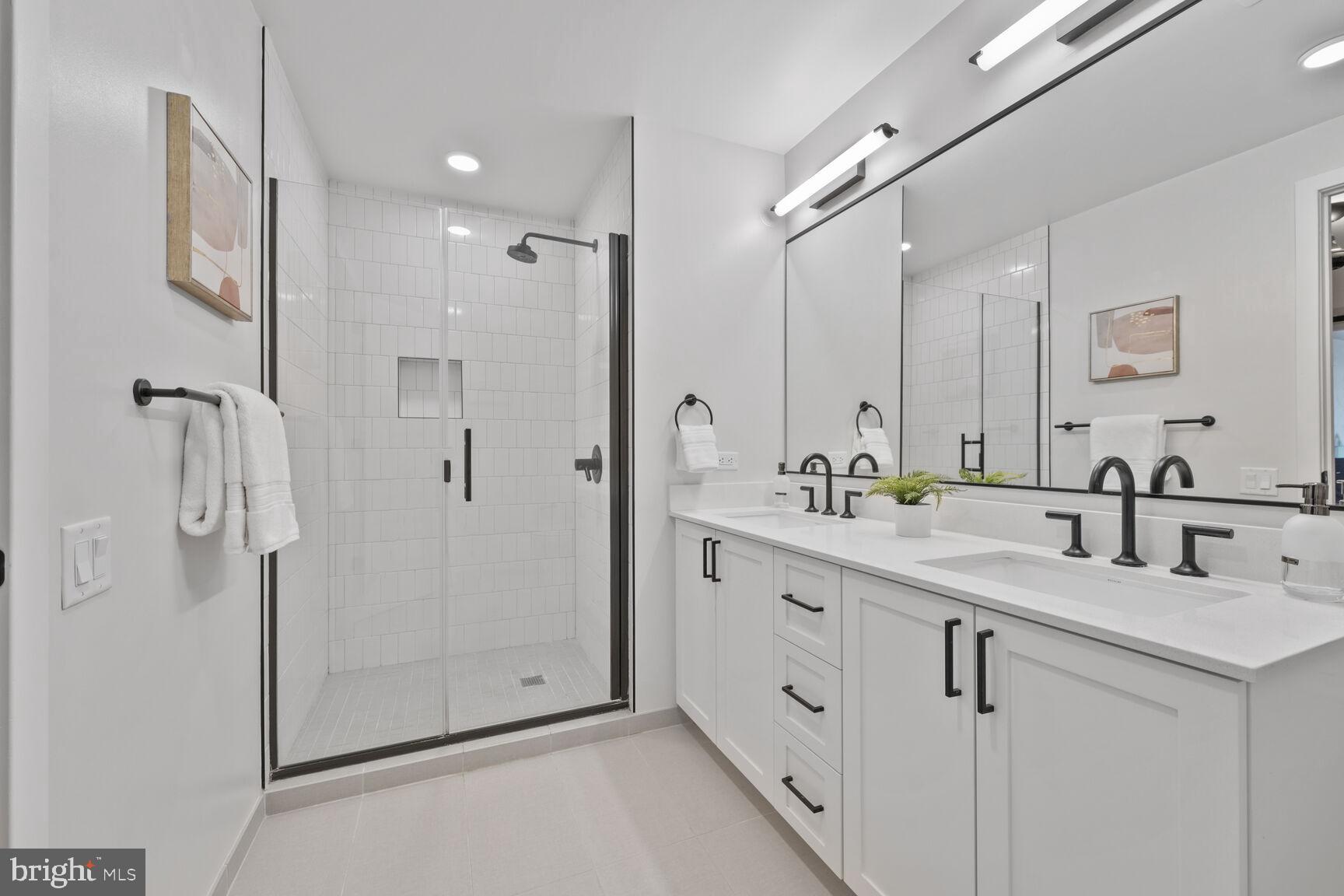 1211 Van Street Southeast, Unit 613 Washington, DC 20003 - Photo 15 of 28 a bathroom with a double vanity sink mirror and shower
