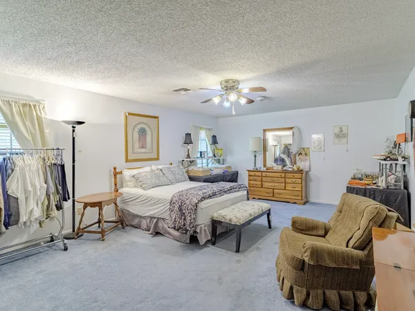 a spacious bedroom with bed and a couch