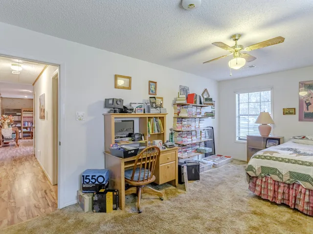a spacious bedroom with a bed and ceiling fan