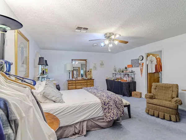 a spacious bedroom with a bed and ceiling fan
