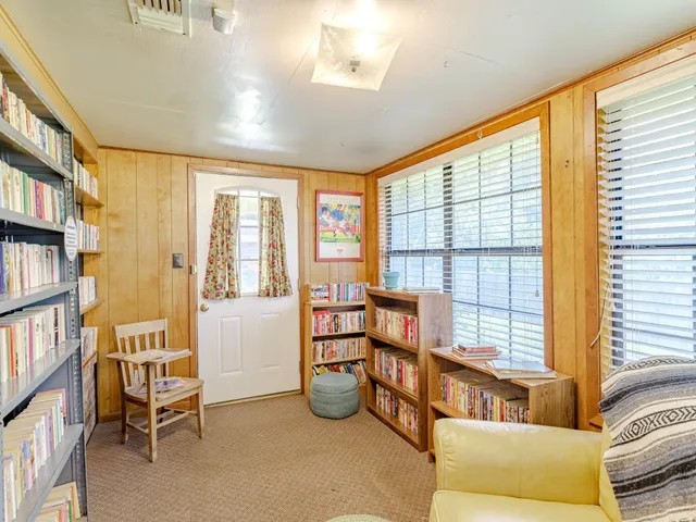 a living room with furniture and a book shelf