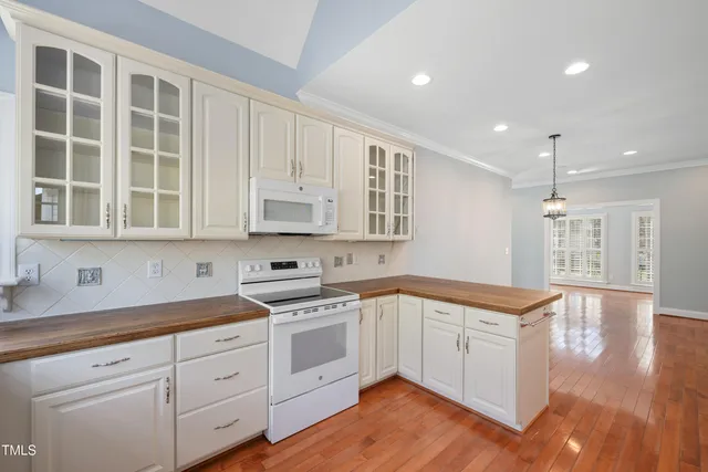 a kitchen with granite countertop white cabinets and white appliances