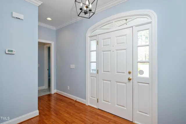 wooden floor in an entryway with a door