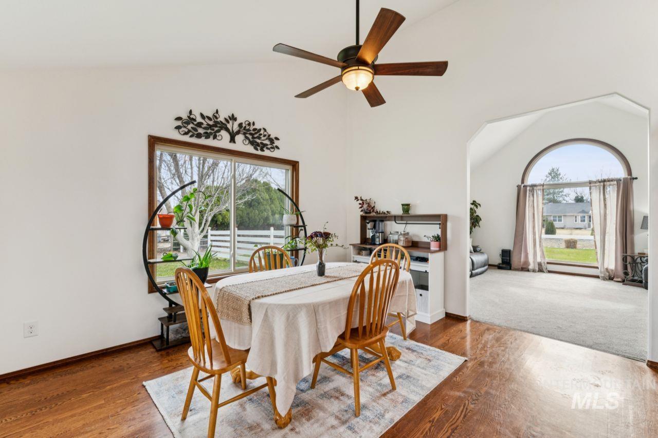 710 Keogh Lane Caldwell, ID 83607 - Photo 19 of 50 Dining room featuring vaulted ceiling, wood finished floors, a ceiling fan, and healthy amount of natural light