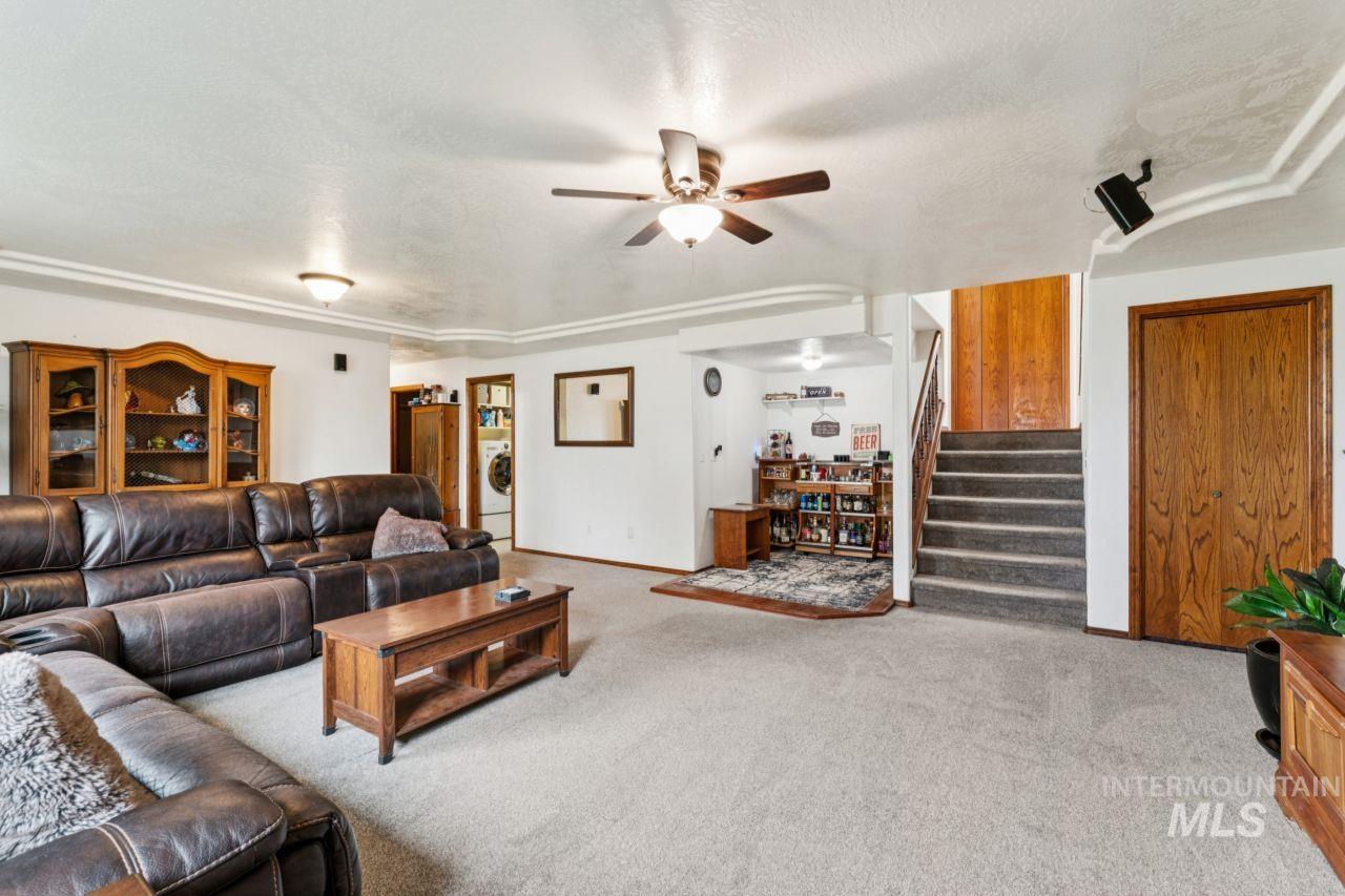 710 Keogh Lane Caldwell, ID 83607 - Photo 32 of 50 Living room featuring light colored carpet, a textured ceiling, a ceiling fan, and washer / clothes dryer