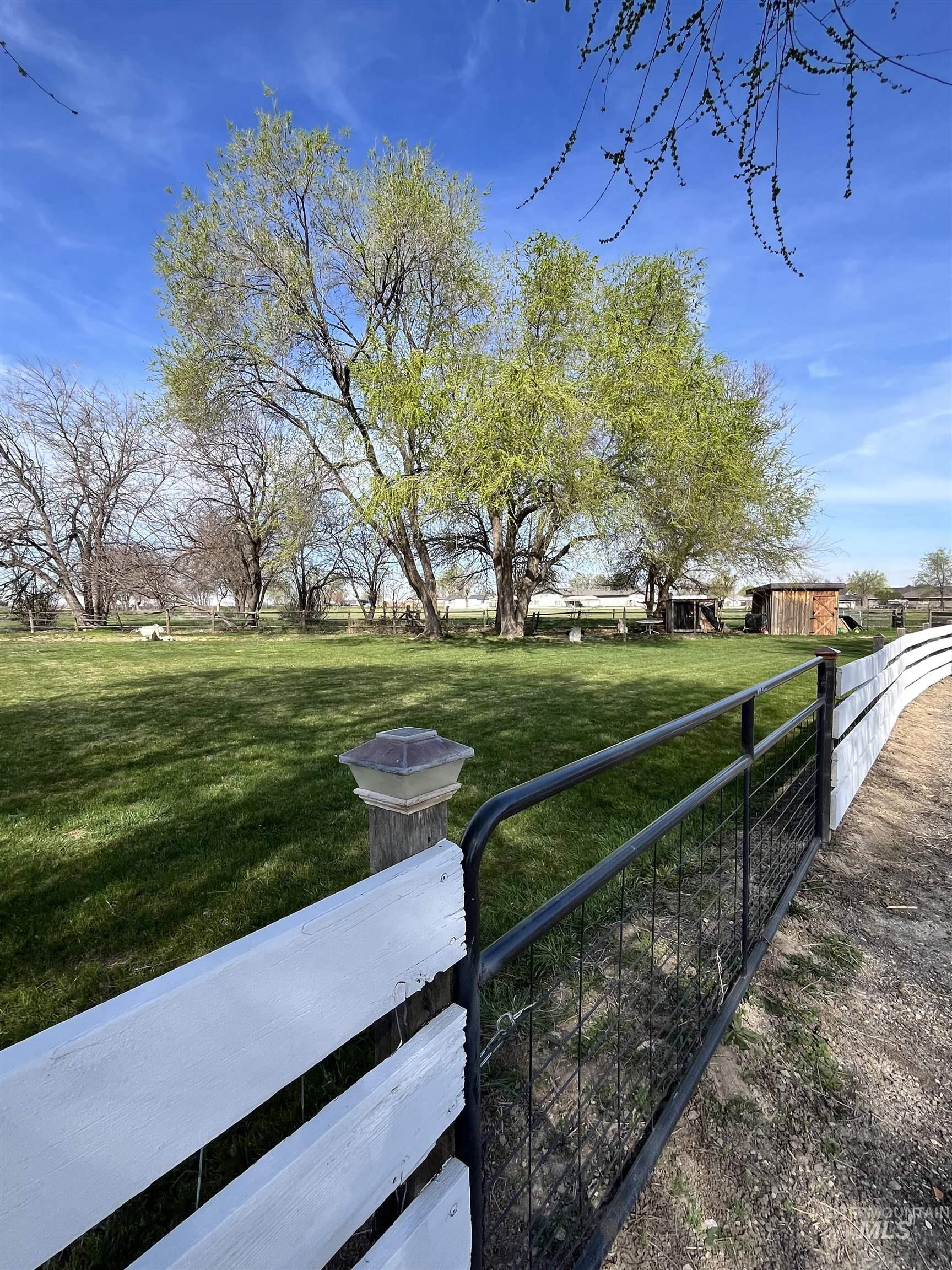 710 Keogh Lane Caldwell, ID 83607 - Photo 4 of 50 Expansive green lawn with mature trees under a clear sky