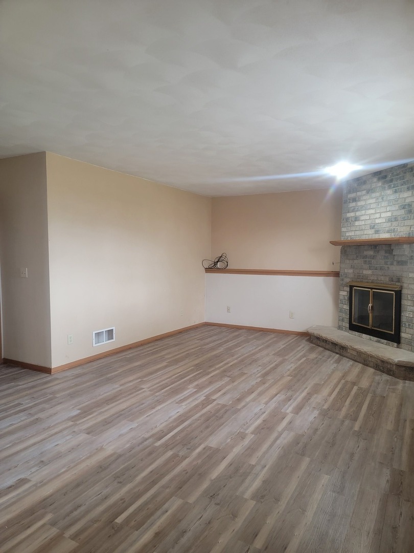 614 Bayfield Road Rockton, IL 61072 - Photo 20 of 42 a view of empty room with wooden floor and fireplace
