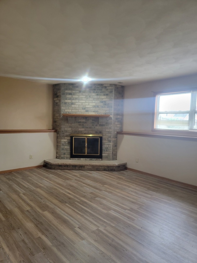 614 Bayfield Road Rockton, IL 61072 - Photo 22 of 42 an empty room with wooden floor and fireplace