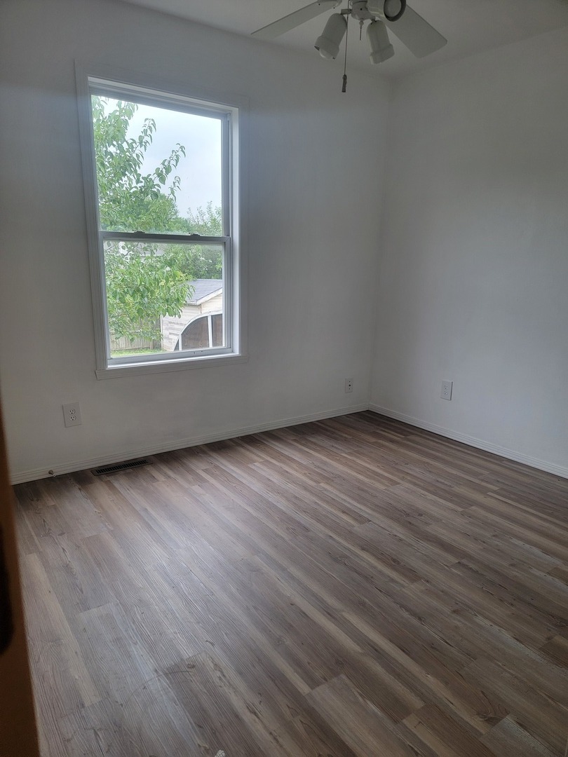 614 Bayfield Road Rockton, IL 61072 - Photo 10 of 42 an empty room with wooden floor and windows