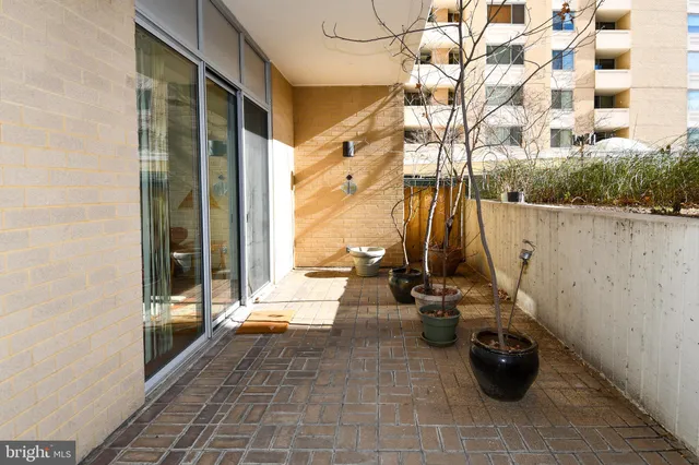 a view of a balcony with chairs and potted plants