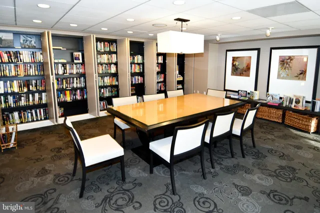 a kitchen with stainless steel appliances kitchen island granite countertop a table chairs in it and wooden floors