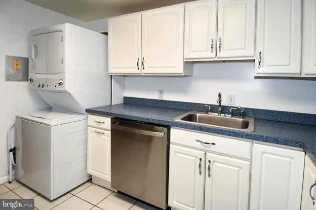 a kitchen with white cabinets and sink