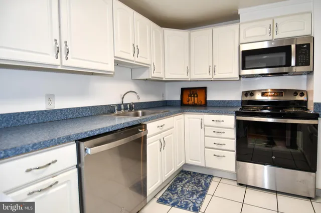 a kitchen with granite countertop white cabinets and appliances
